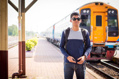 Man standing on train at railroad track