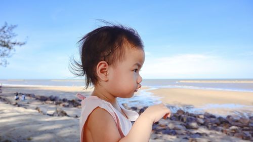 Happy girl on beach against sky