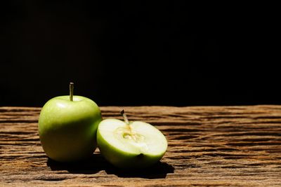 Close-up of apple on table against black background