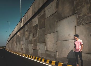 Rear view of men  standing against wall