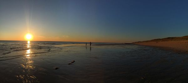 Scenic view of sea against clear sky at sunset