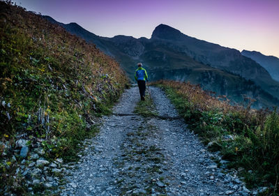 Rear view of man on mountain against sky