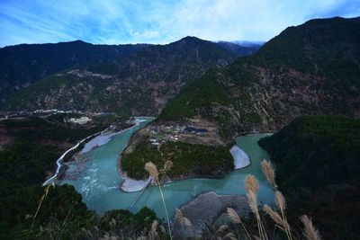 High angle view of lake and mountains against sky