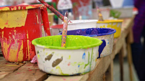 Close-up of colorful paints in containers on table