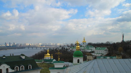Buildings in city against cloudy sky