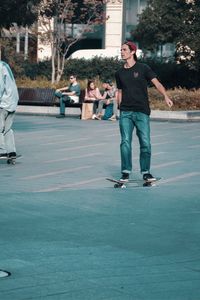 Full length of man standing on skateboard in city