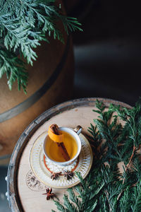 Festive holiday winter hot toddy in teacup on whiskey barrel