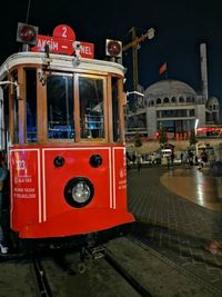 Red telephone booth on street in city at night