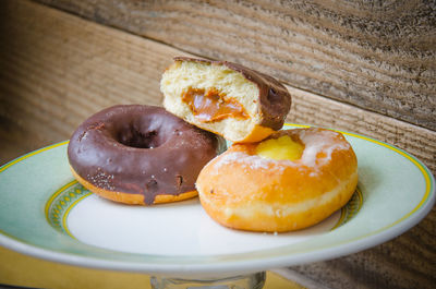 Close-up of donuts in plate on wooden table