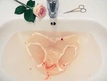 Stained underwear under running water in sink