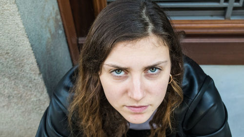 High angle portrait of young woman sitting outdoors