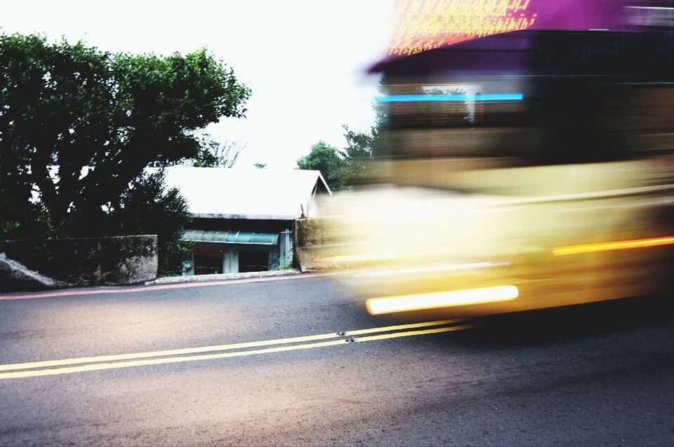 transportation, road, car, the way forward, road marking, motion, street, land vehicle, mode of transport, blurred motion, on the move, speed, built structure, diminishing perspective, tree, architecture, sunlight, asphalt, clear sky, outdoors