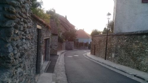 Empty road along buildings