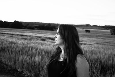 Side view of woman in field against clear sky