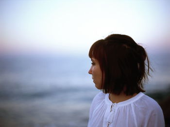 Woman looking away against sky