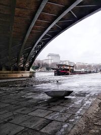 Cars on bridge in city against sky