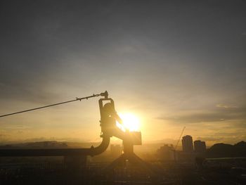 Silhouette man standing on landscape against sky during sunset