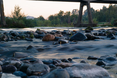 Surface level of stones on shore against sky