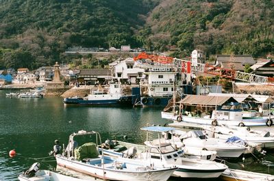 High angle view of boats moored at harbor by buildings