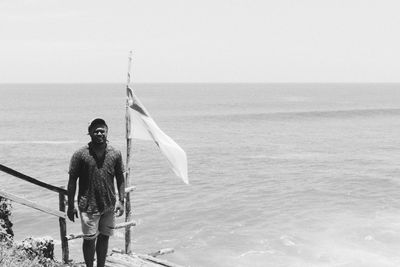 Man standing in sea against sky