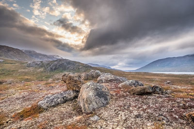 Scenic view of mountains and lake against cloudy sky