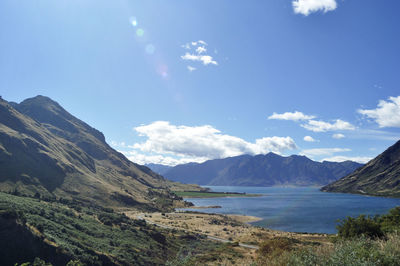 Scenic view of sea and mountains against sky