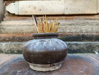 Close-up of pot on table against wall