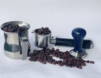 Coffee beans on table against white background