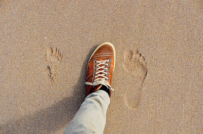 Low section of woman on sand