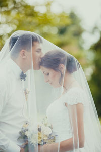 Midsection of couple with umbrella