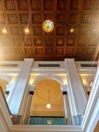 Low angle view of illuminated pendant light in building