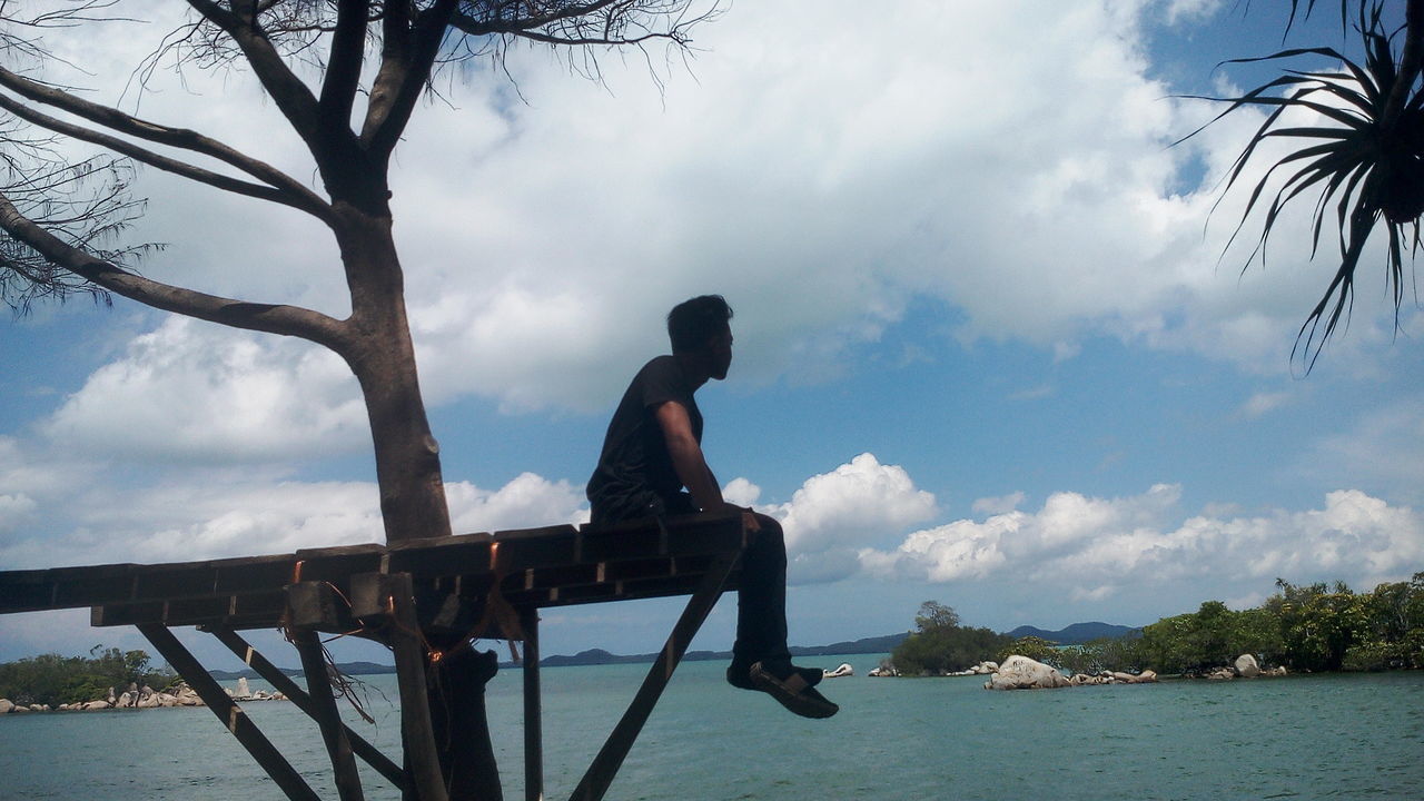 sky, water, cloud - sky, one person, tree, real people, nature, sea, men, day, full length, side view, leisure activity, beauty in nature, plant, outdoors, lifestyles, scenics - nature