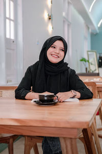 Portrait of young woman reading book