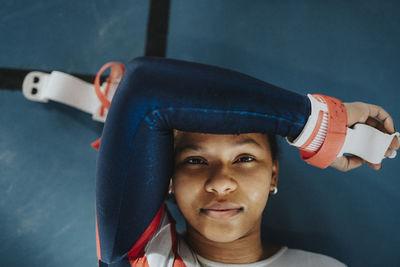 Directly above portrait of female athlete resting on floor