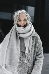 Smiling woman with gray hair wrapped in scarf