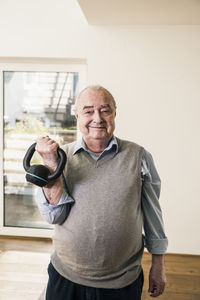 Portrait of smiling senior man doing a weight exercise