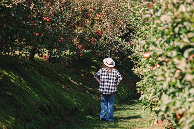 Rear view of woman walking on field