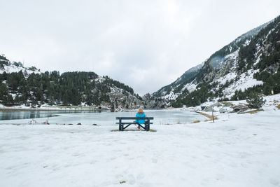 Woman on snowcapped mountain against sky