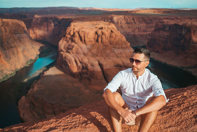 Young man sitting on rock formations