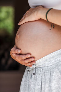 Midsection of pregnant woman touching stomach