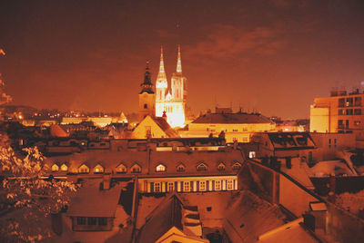 Illuminated cityscape against sky at night