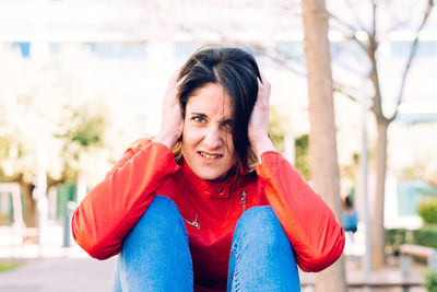 Portrait of woman covering ears at outdoors