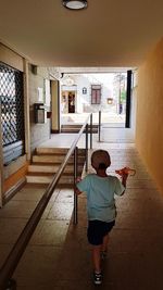 Rear view of boy standing at home