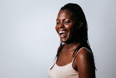 Laughing young woman against gray background