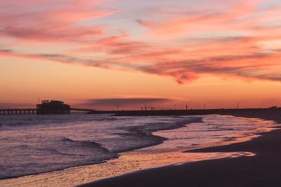 Scenic view of sea against cloudy sky during sunset