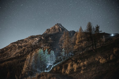 View of a summit and a person against sky at night