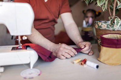 Midsection of woman using sewing machine