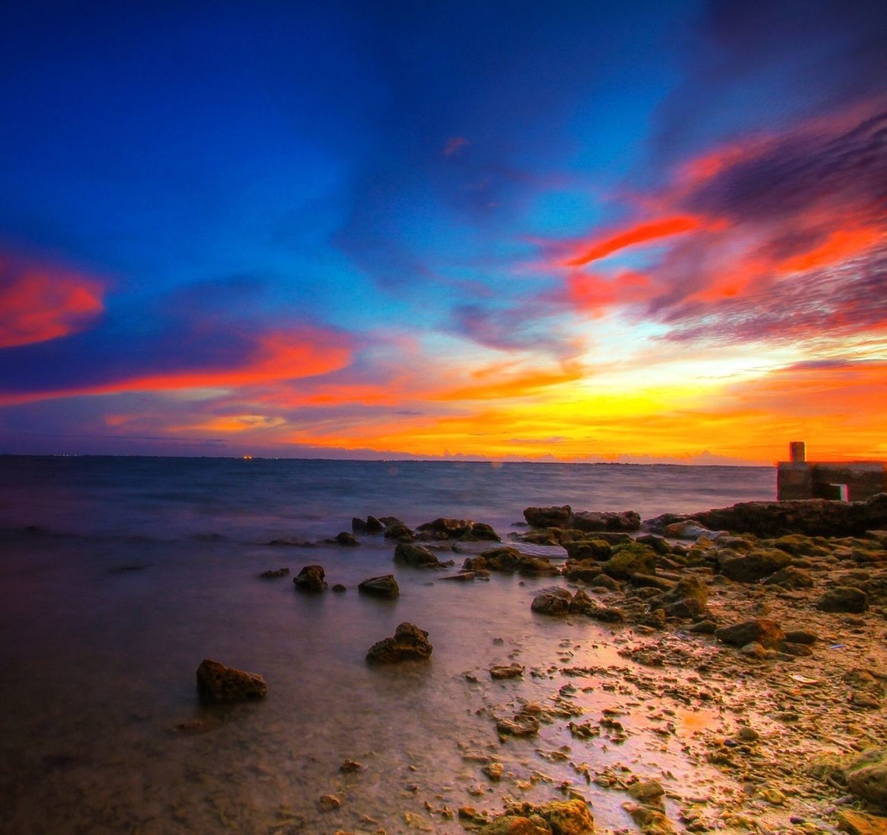 sunset, sea, water, horizon over water, sky, scenics, tranquil scene, beauty in nature, tranquility, orange color, beach, cloud - sky, idyllic, nature, shore, built structure, dramatic sky, cloud, building exterior, architecture