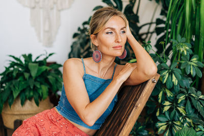 Portrait of a young attractive woman sitting in a chair in a flower studio.