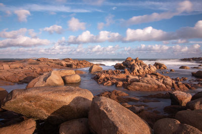 Rocks on beach against sky